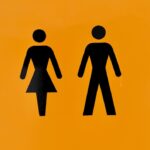 a yellow sign with a picture of a man and a woman